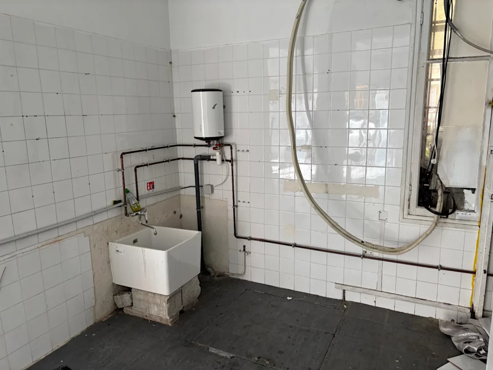 Arrière de l'atelier avec lavabo et murs carrelés, état initial