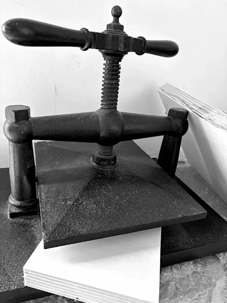 Balise alt : Presse à xylogravure ancienne en fonte et planches de bois de peuplier dans l'atelier de Franck Saissi.